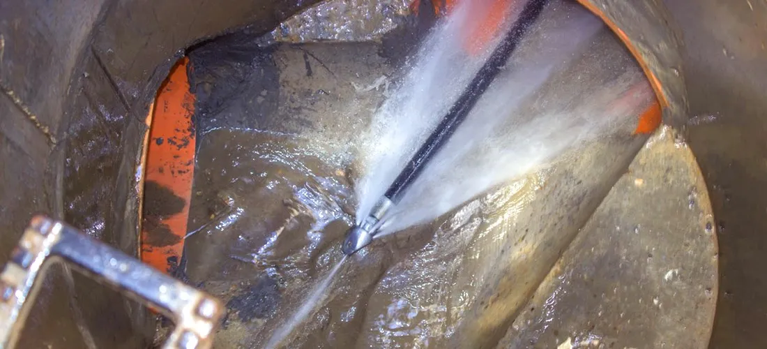 High-pressure water jetting clearing a blocked drain